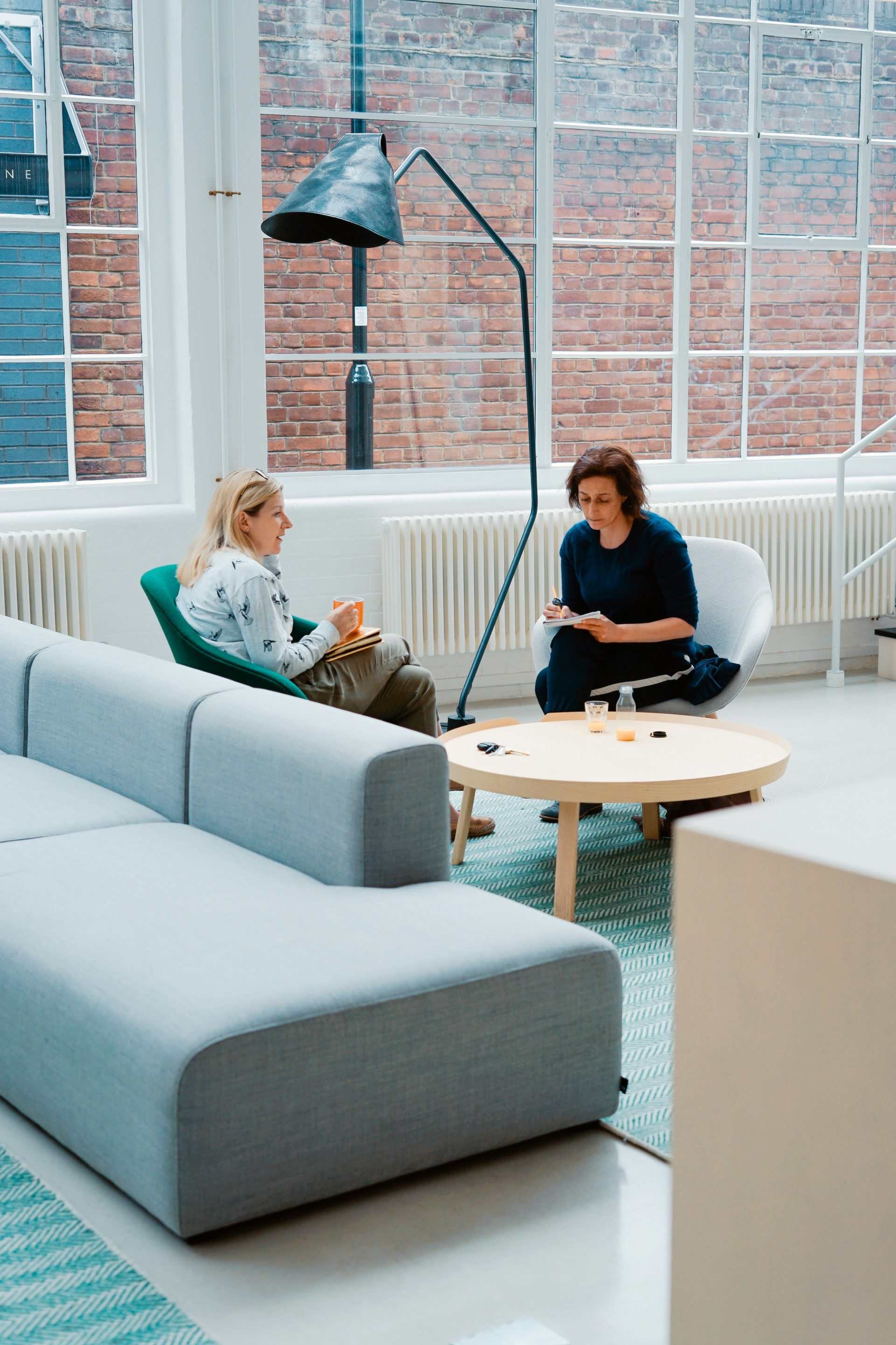 Zwei Frauen sitzen auf Sofasesseln im Haus